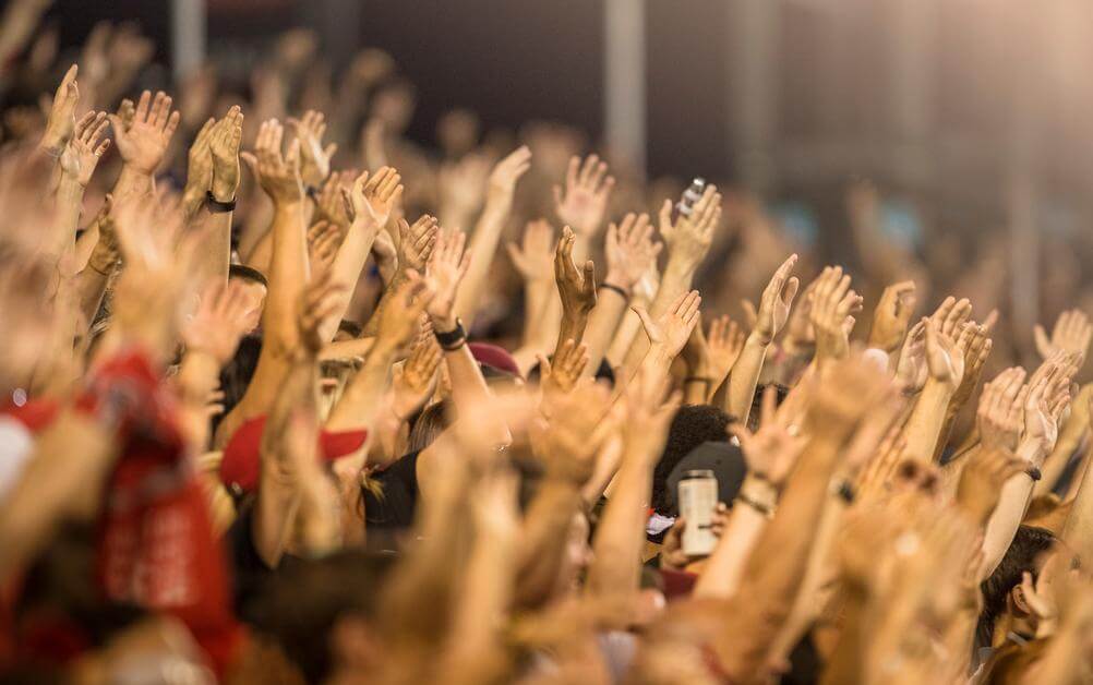 A crowd at a football match applauding a punter who knew what correct score betting is.